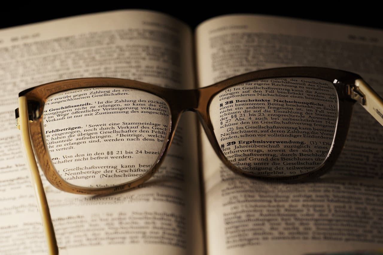 Reading glasses resting on the open pages of a printed book