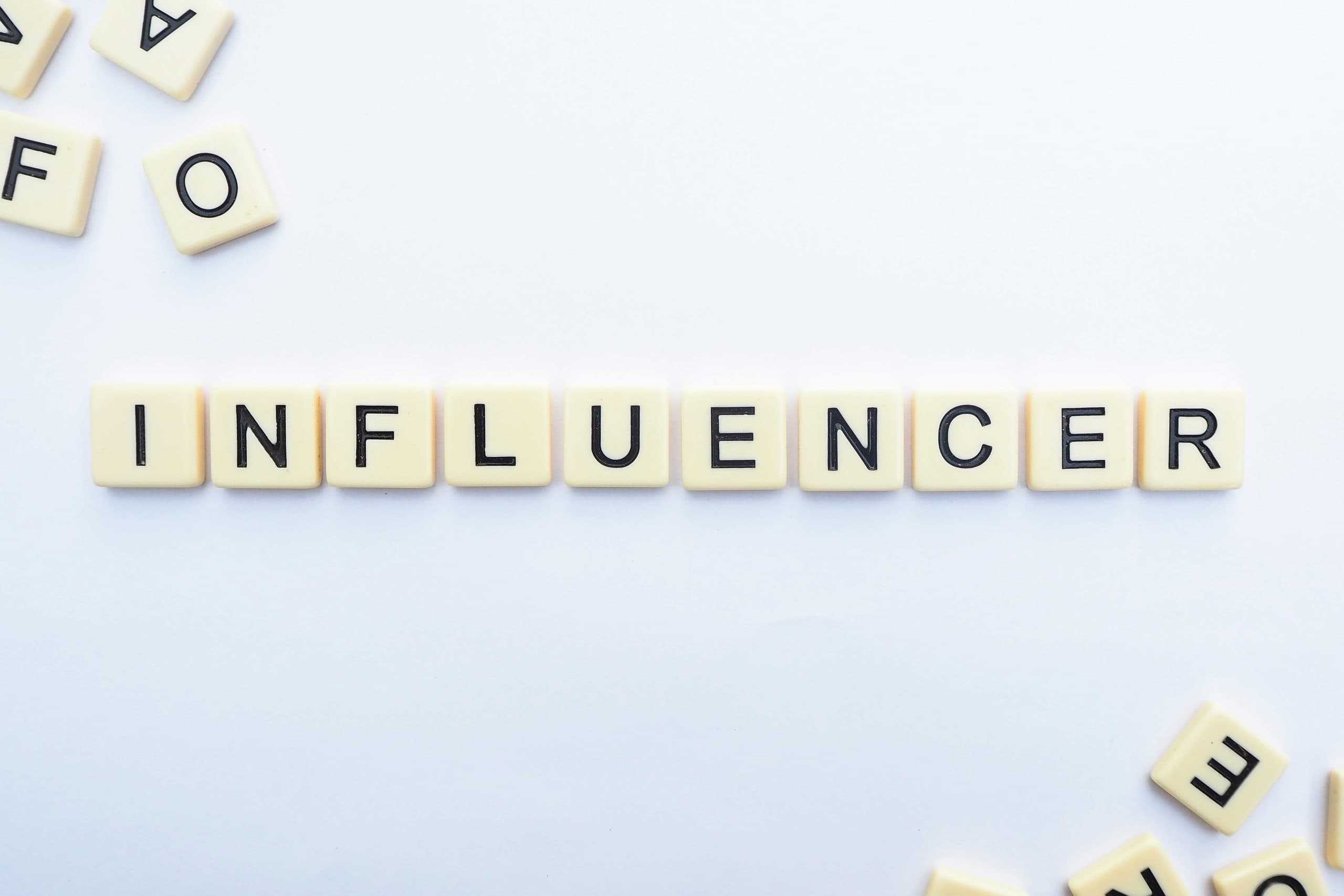 Letter tiles spelling the word influencer on a white surface